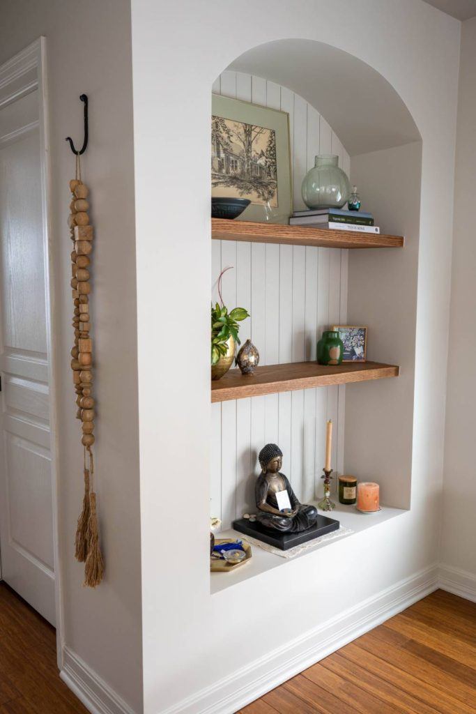 a shelf in a room with a statue on top of it
