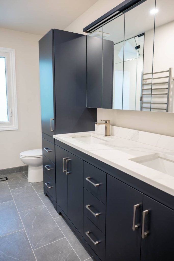 a bathroom with a toilet, sink, and mirror