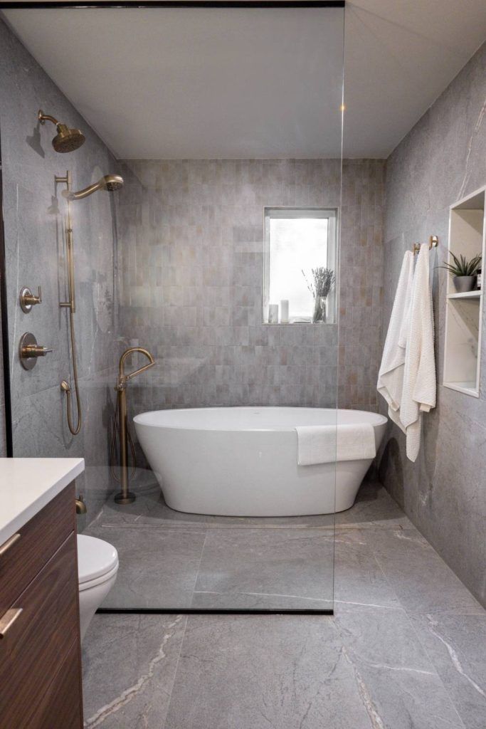 a white bath tub sitting next to a walk in shower