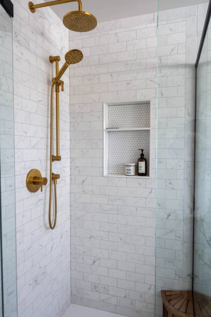 a bathroom with a walk in shower next to a window