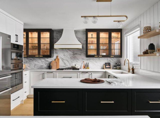 a kitchen with marble counter tops and black cabinets